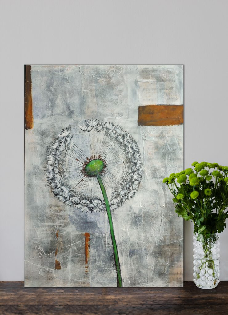 The dandelion painting standing on the ground next to a vase of green flowers.