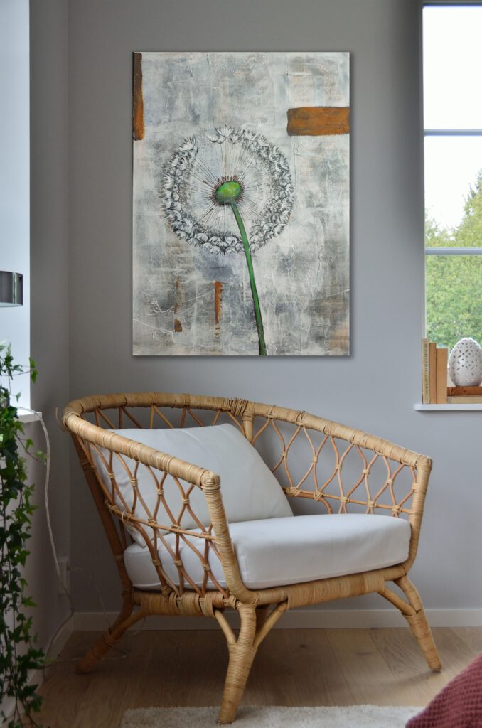 The painting of the dandelion hanging on the wall in the corner of a room.