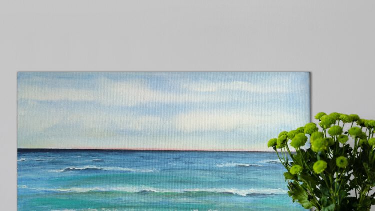 The beach painting standing on wooden floor, next to a flower vase.
