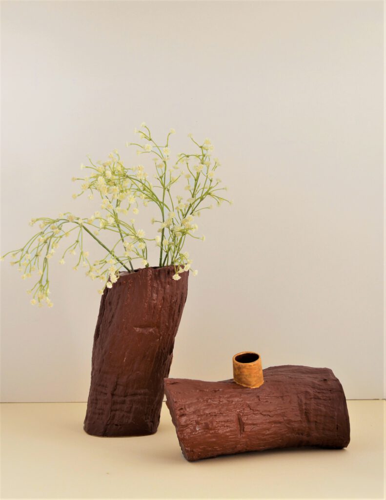 A ceramic urn of a tree trunk; in two parts.
